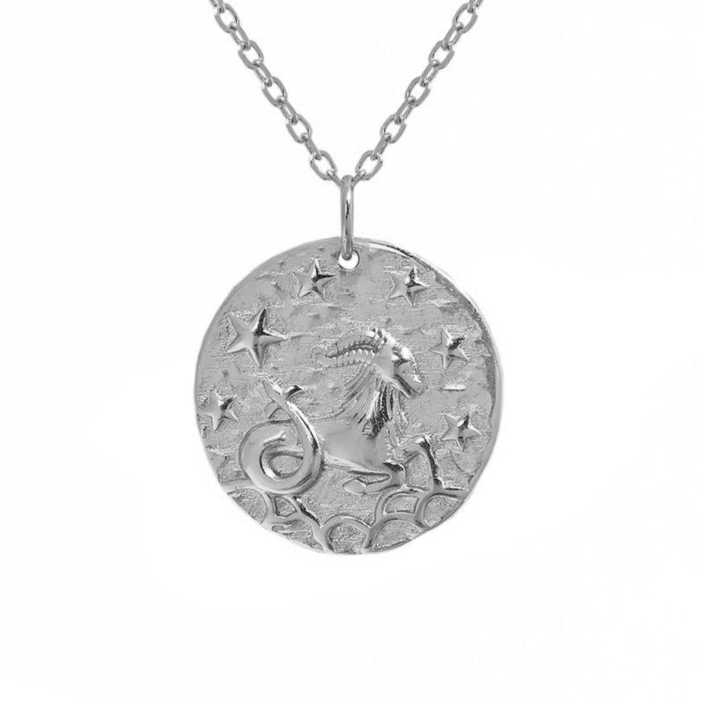 Collier en argent avec pendentif Capricorne, gravure détaillée du signe astrologique et étoiles sur fond blanc épuré. Idée cadeau femme.
